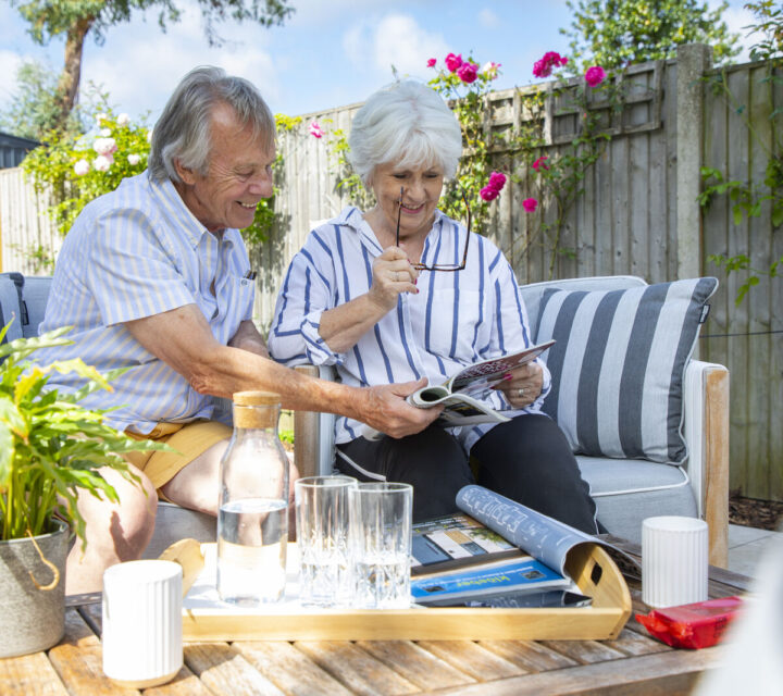 A couple looking through a magazine in a garden